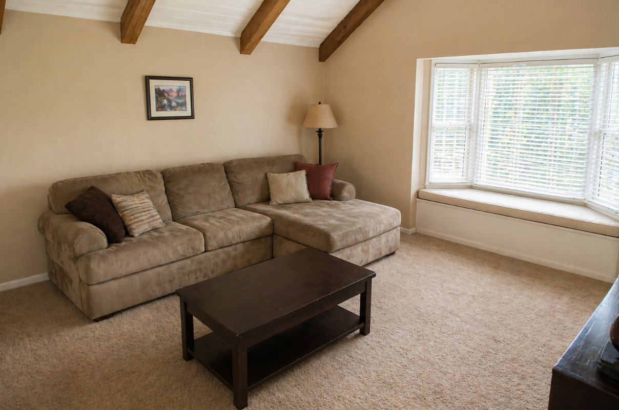 Plain beige living room before farmhouse makeover with tan sofa and basic furniture